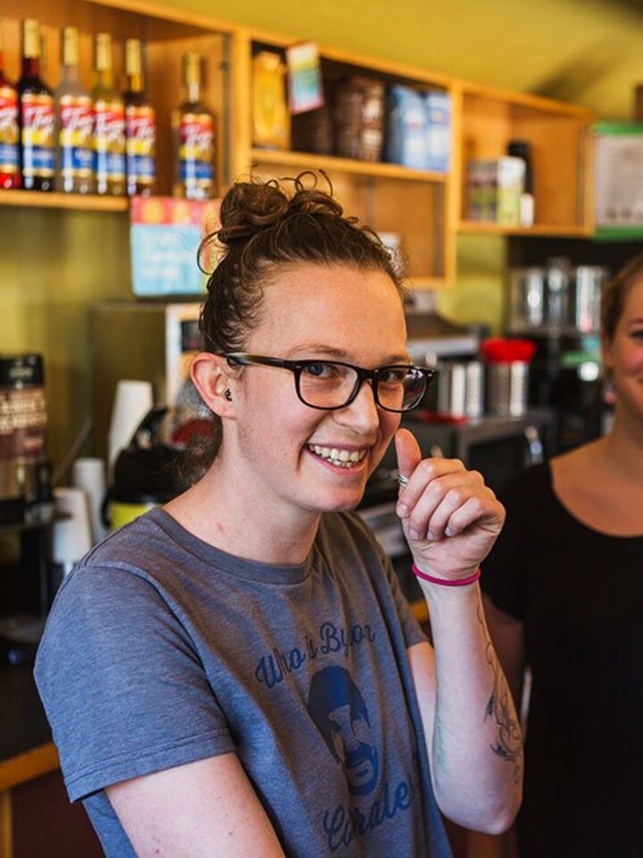 A Rock Salt barista giving a thumbs up behind the café counter